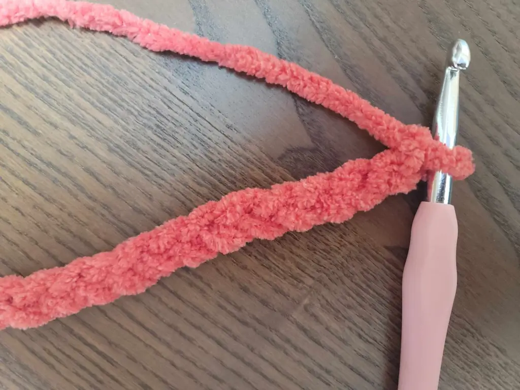 Perfect Phase Blanket yarn in "Crimson" stitched as a foundation chain with hook still in loop.