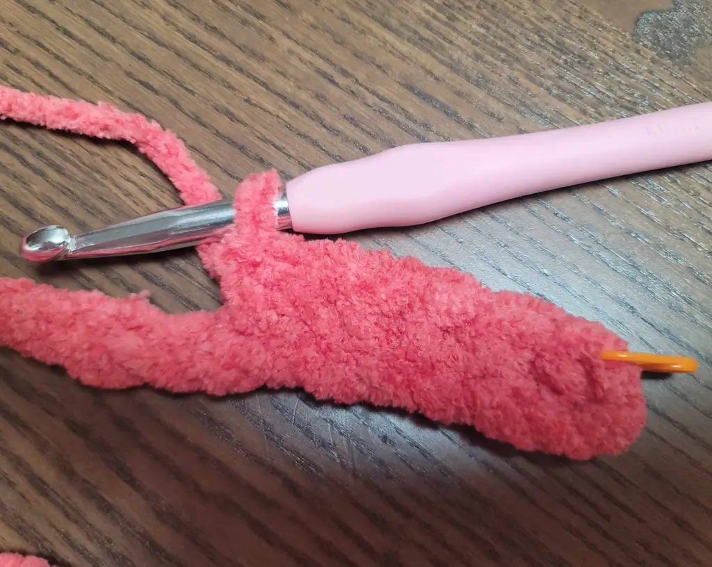 Perfect Phase Blanket yarn in "Crimson" with hook still in loop and orange stitch marker on first stitch of the row.