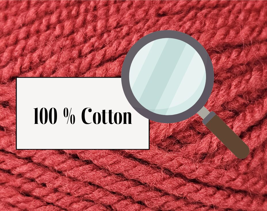 Red yarn in the background with a white label on it stating 100% cotton and a magnifying glass over the label.