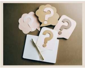 Question marks next to a notebook and pen
