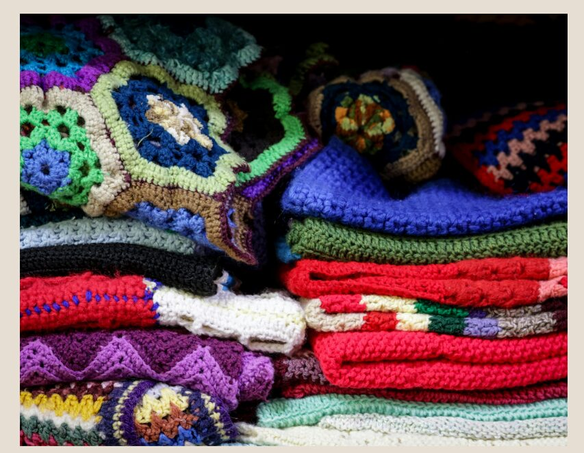 Multiple crochet projects in two piles and in different colors