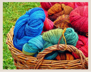 light brown basket filled with unlabeled multicolor yarn skeins