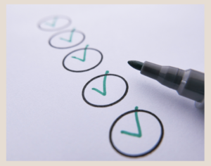 White piece of paper with circles indicating a list of to-do items with check marks made by pen showing completed.